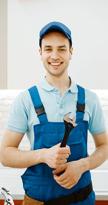 A happy plumber on duty holding a wrench